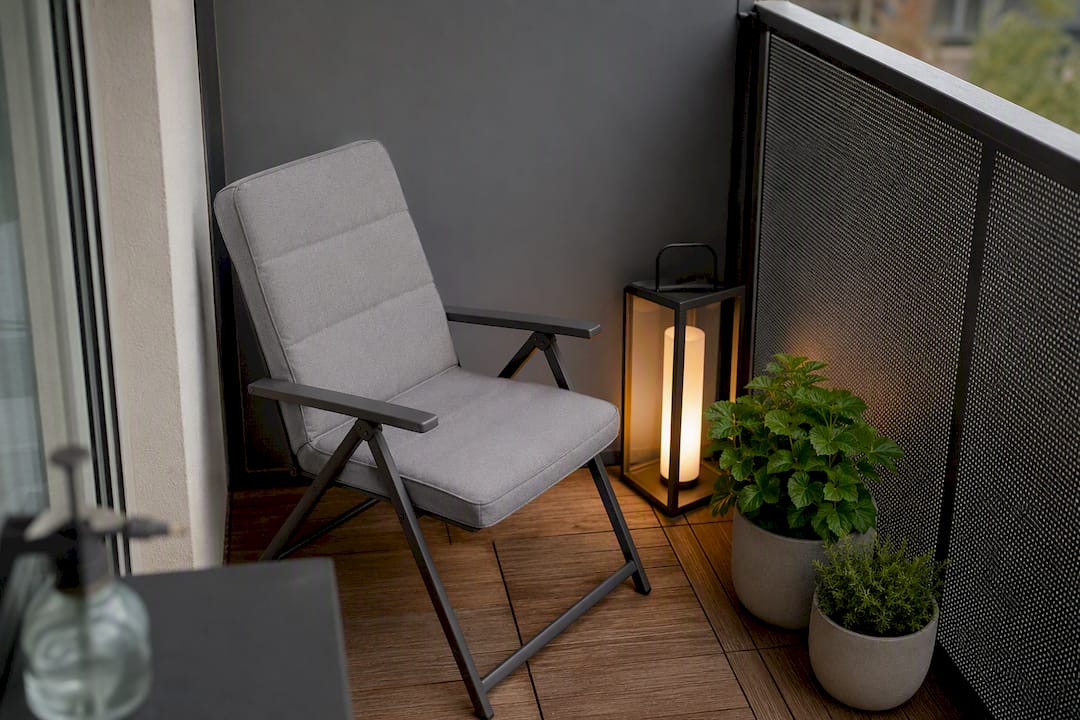 Minimalistischer Balkondeko-Stil: Klar, schlicht, funktional 4 Kleiner, modern gehaltener Balkon mit stimmungsvoller Laterne und grünen Pflanzen